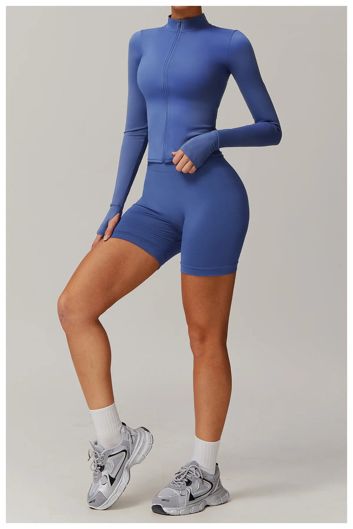 Xooie Fit women's fitness jacket with thumb holes in blue, paired with matching shorts and sneakers
