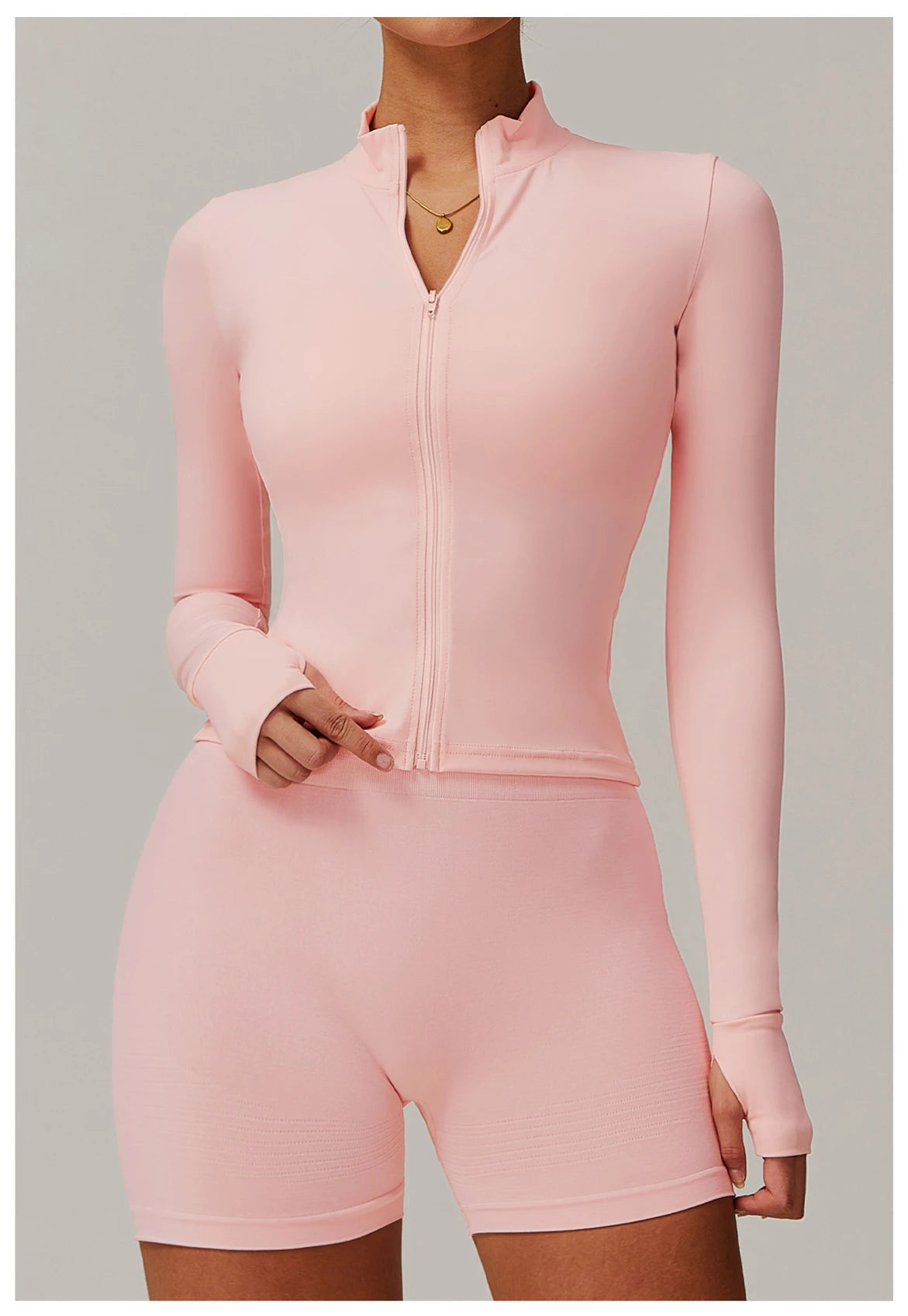 Xooie Fit women's fitness jacket with thumb holes in light pink, full zip front and long sleeves