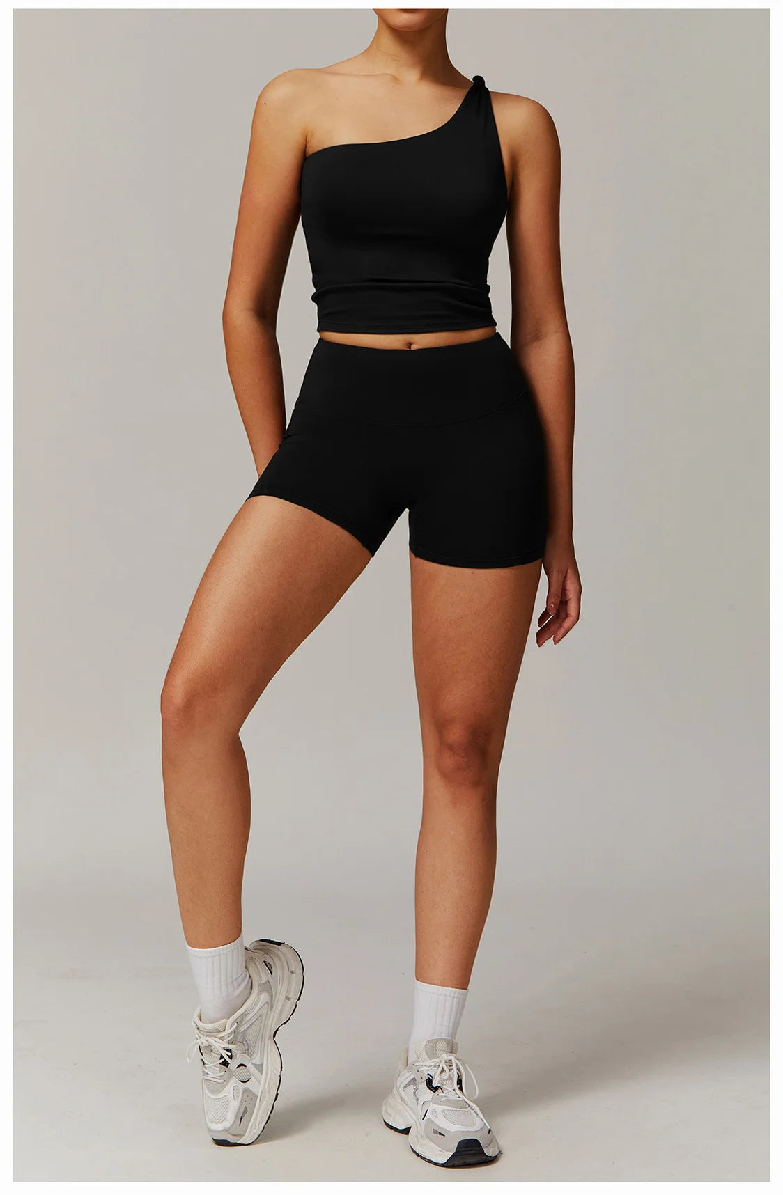 Xooie Fit two-piece women's fitness matching set with one-shoulder crop top and high-waisted shorts in black