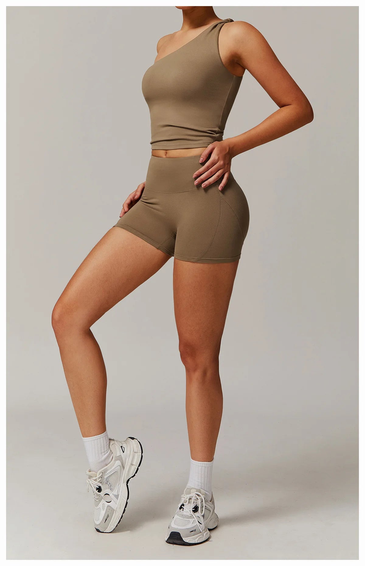 Xooie Fit women's fitness matching set in brown featuring a one-shoulder crop top and high-waisted shorts