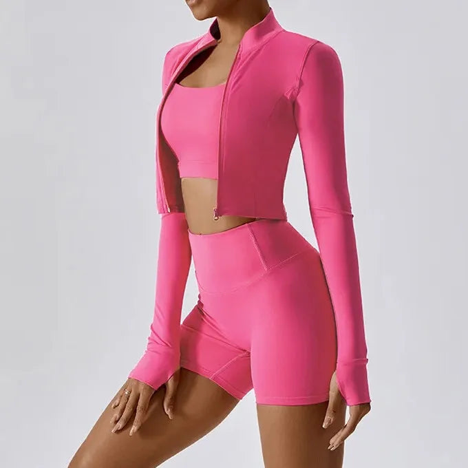 Xooie Fit women's fitness matching set in vibrant pink with a crop top, shorts, and long-sleeve jacket