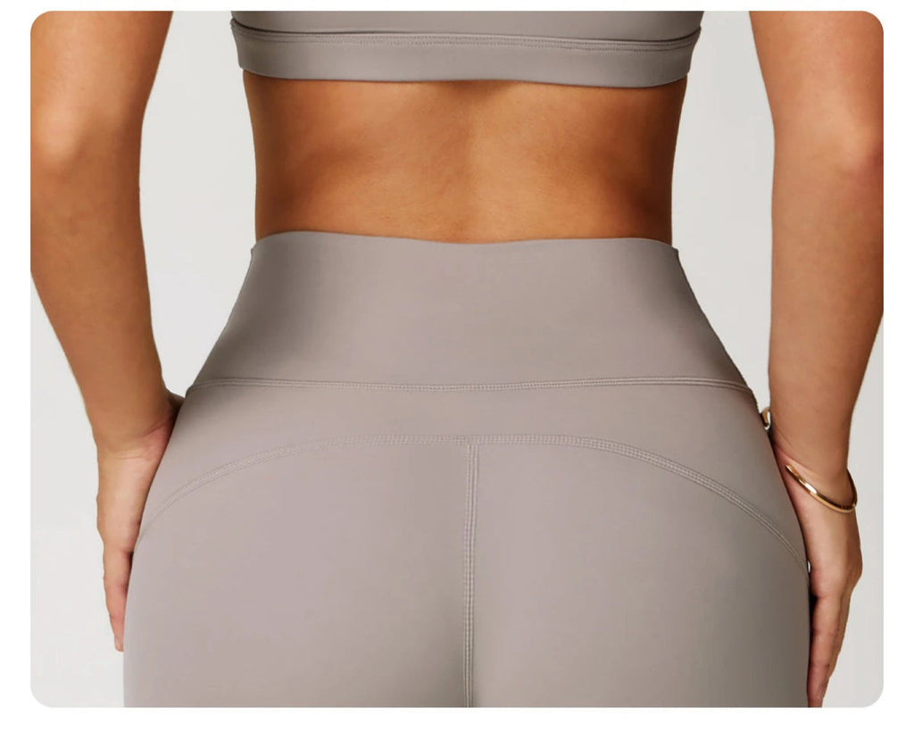 Back view of Xooie Fit women's fitness matching set showing high-waisted leggings and crop top in taupe