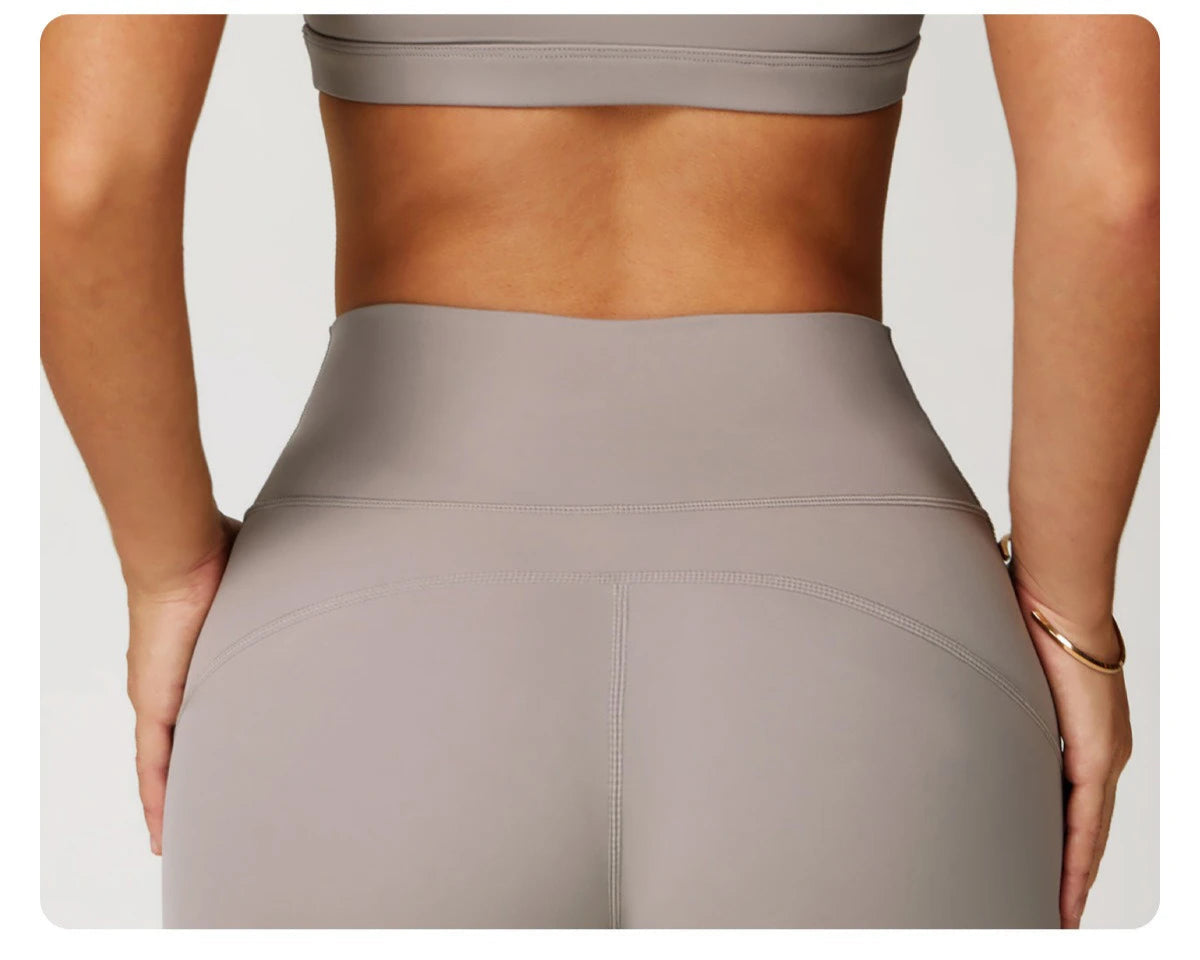 Back view of Xooie Fit women's fitness matching set showing high-waisted leggings and crop top in taupe