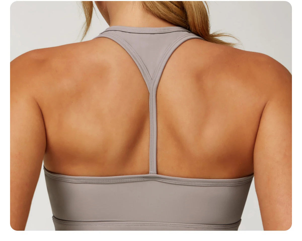 Back view of woman wearing Xooie Fit women's fitness matching set in light gray with racerback design