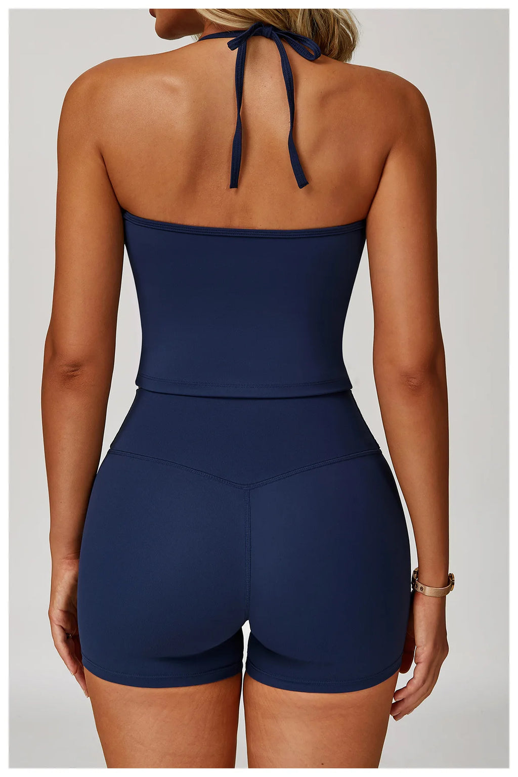 Women's matching activewear set in navy featuring a halter top and high-waisted shorts