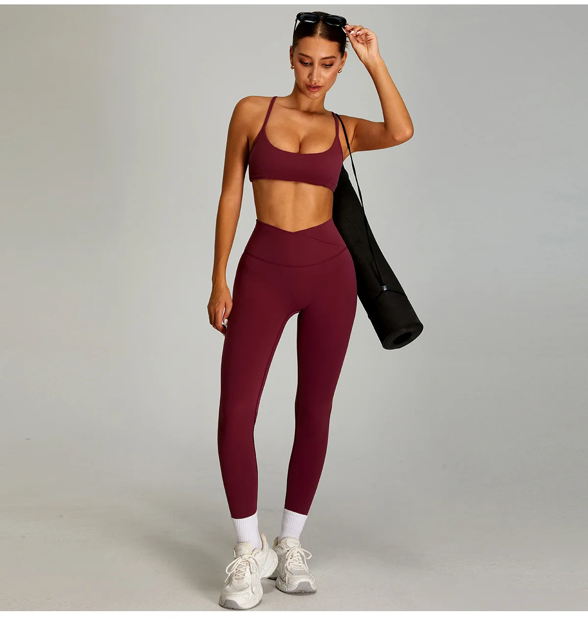 Women's matching workout set in burgundy featuring a crop top and high-waisted leggings