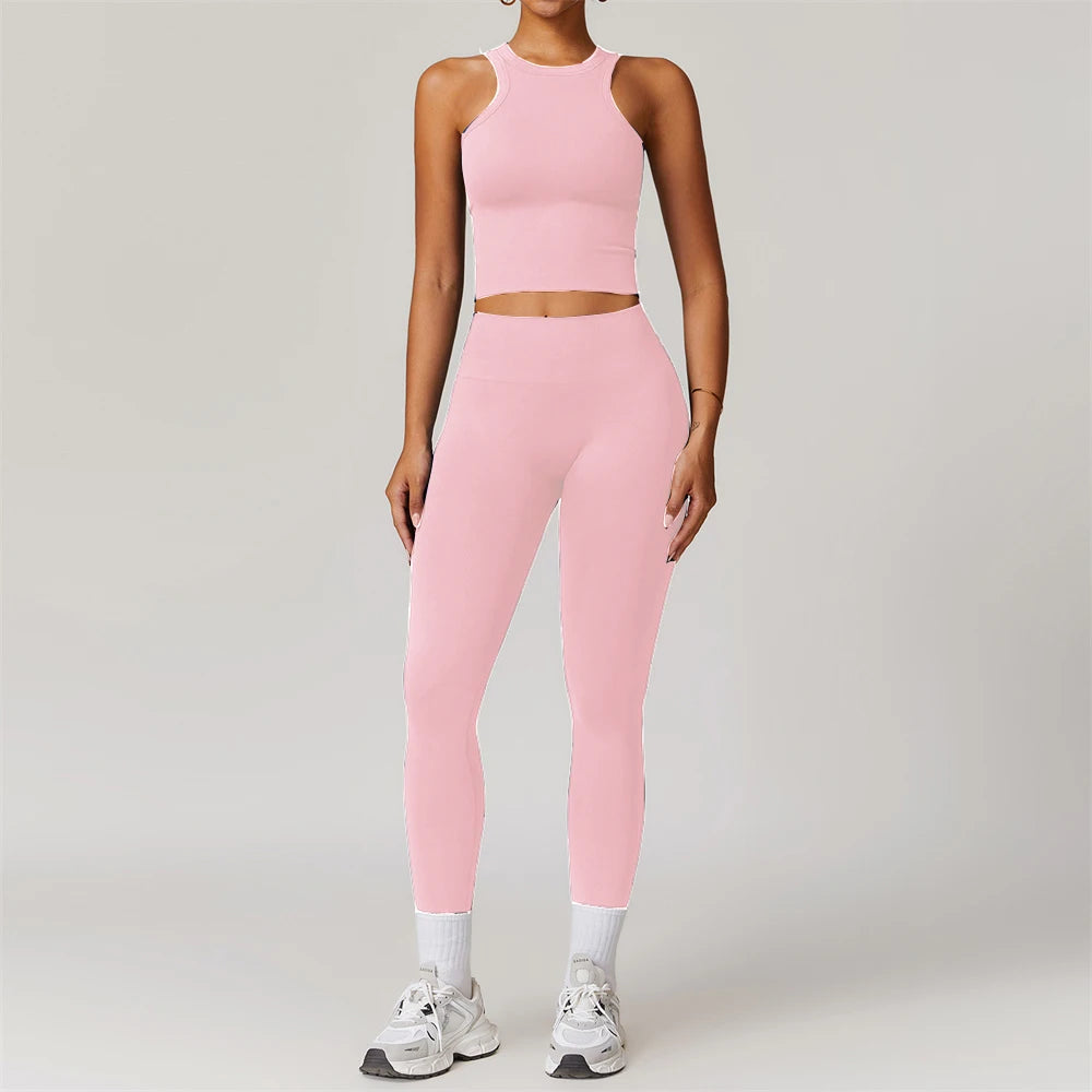 Xooie Fit women's matching workout set in pink featuring a sleeveless crop top and high-waisted leggings