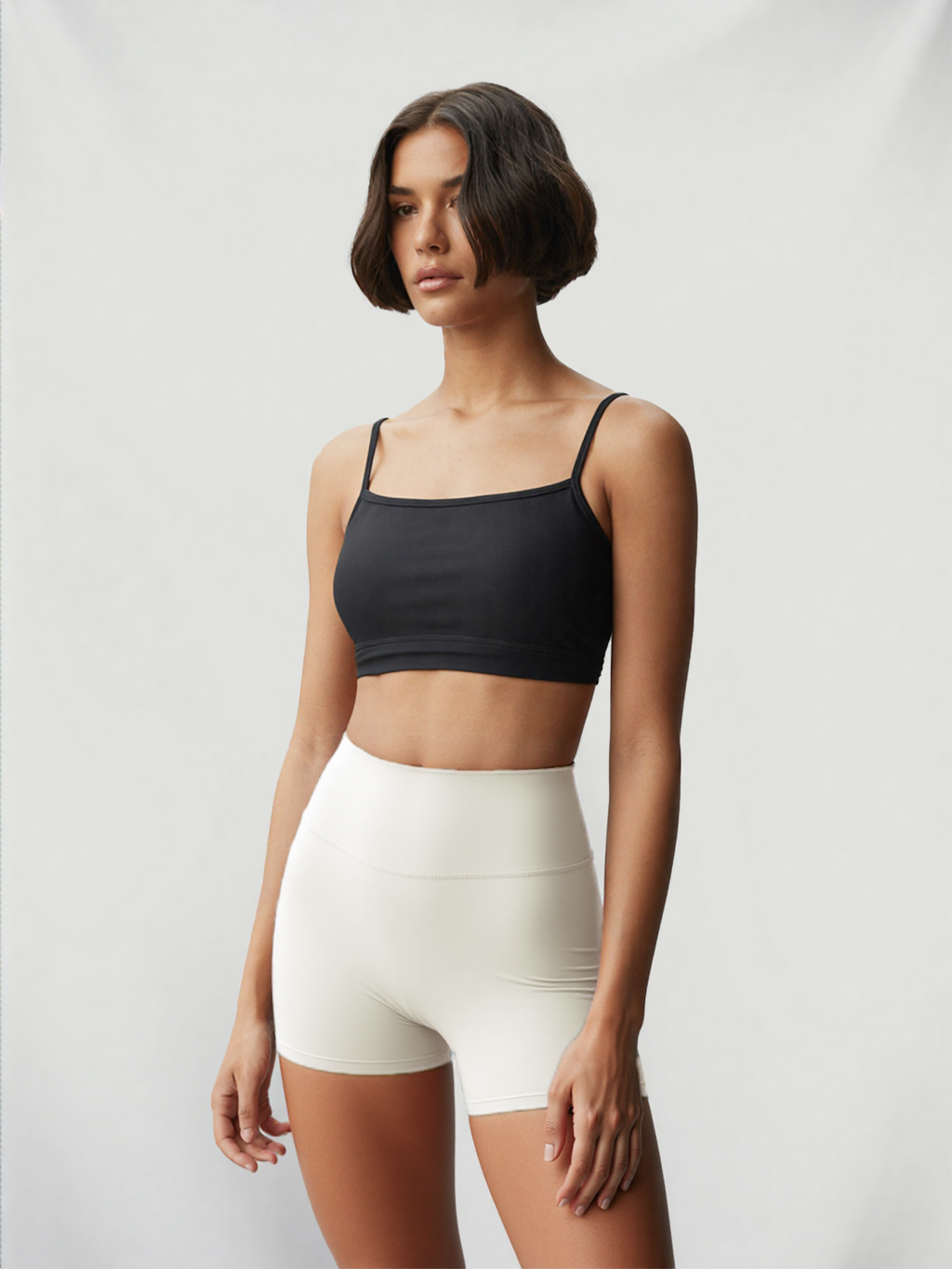 Model wearing Xooie Fit women's stretchy workout shorts in white with a black crop top