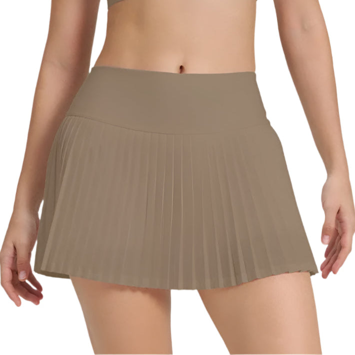 Xooie Fit women's tennis skort with phone pockets in tan, featuring a stylish pleated design