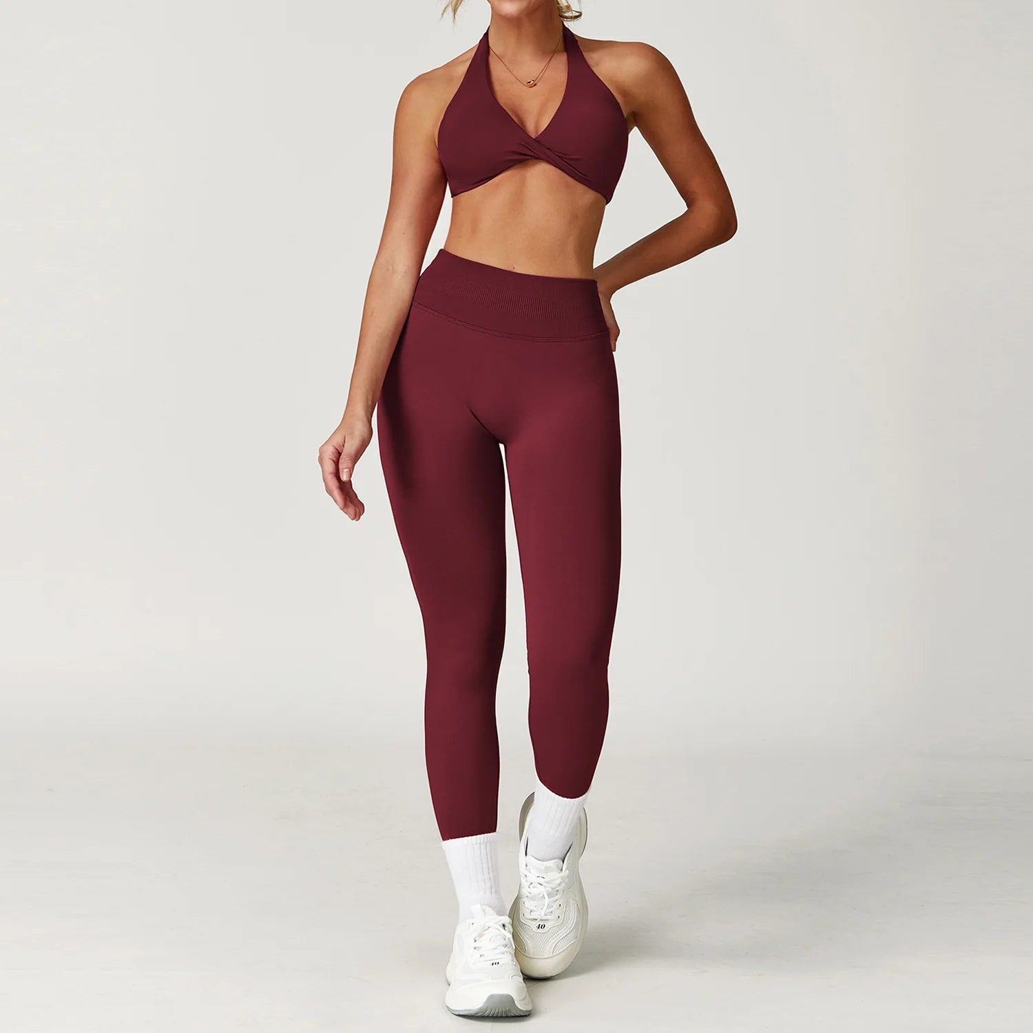 Stylish women's twist bra and high waist leggings set in burgundy, perfect for workouts and casual wear
