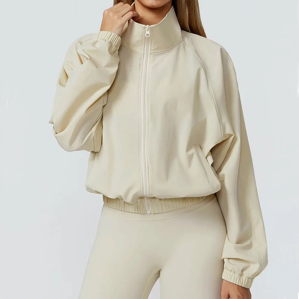 Xooie Fit women's windproof fitness jacket in cream color with a zip closure and relaxed fit