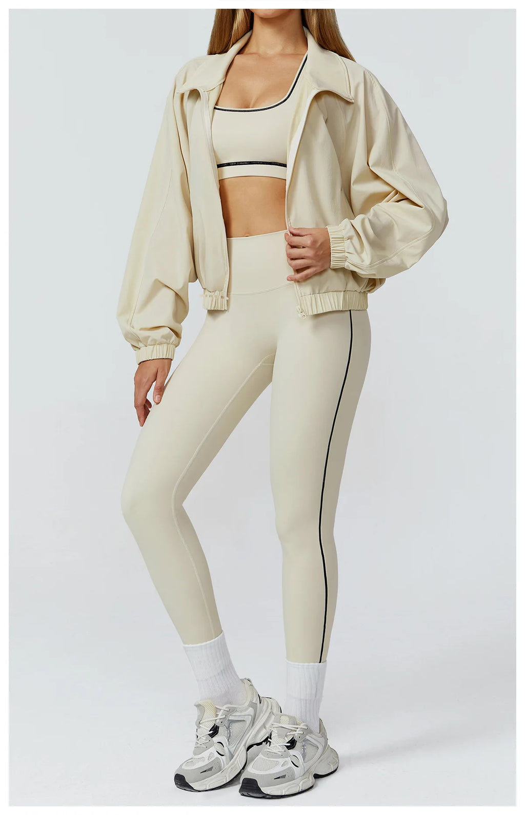 Xooie Fit women's windproof fitness jacket in beige, styled with matching workout leggings.