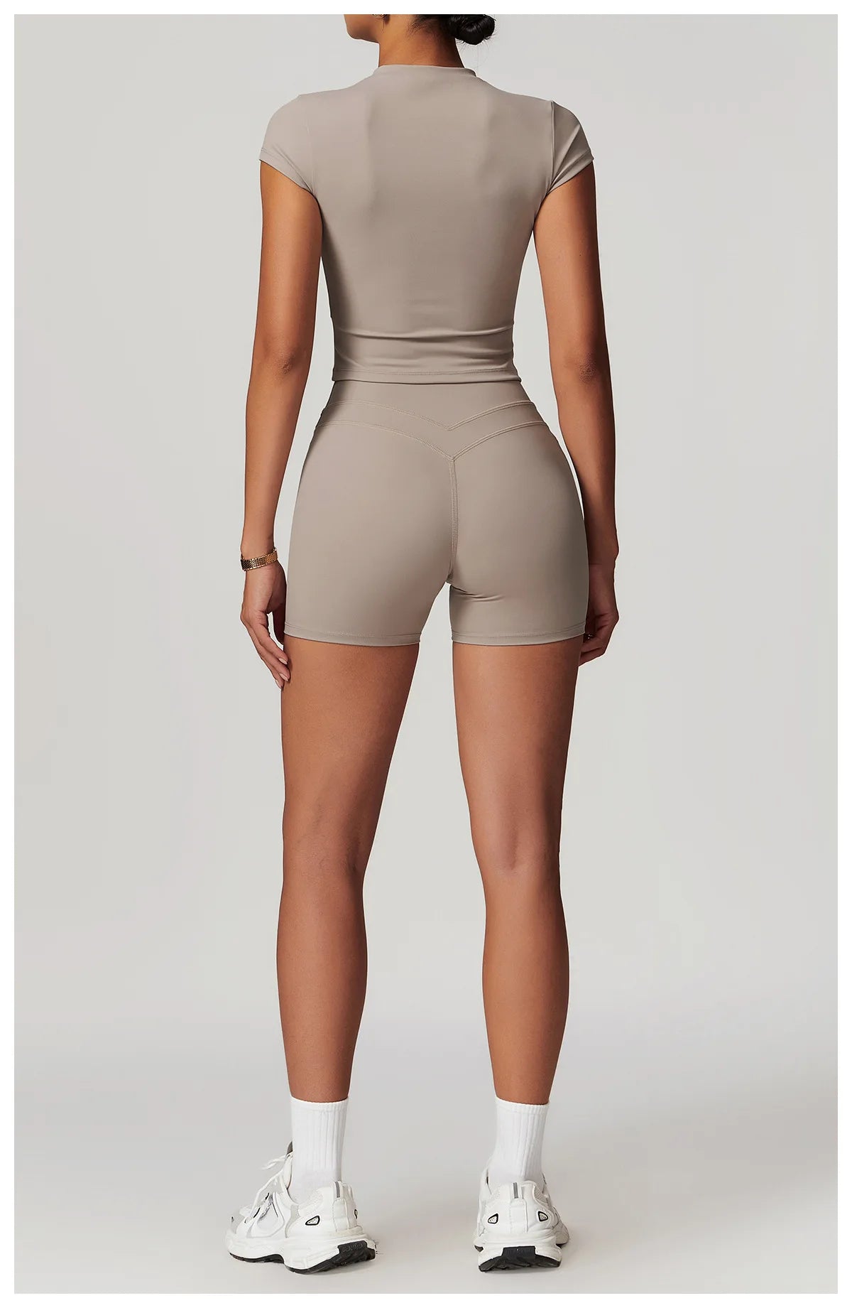Back view of a model wearing Xooie Fit womens workout set with fitted shorts and short sleeve top