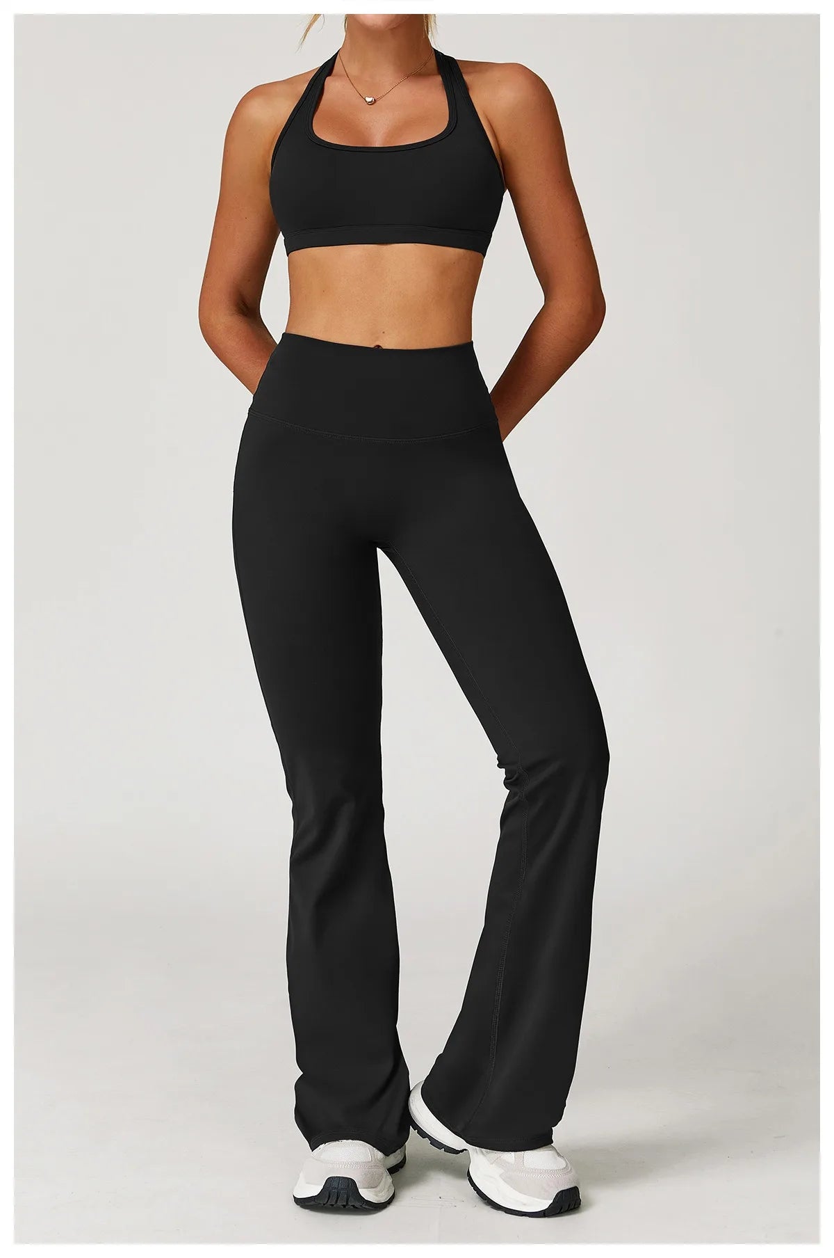 Xooie Fit women's workout set flared pants in black with matching sports bra and white sneakers2