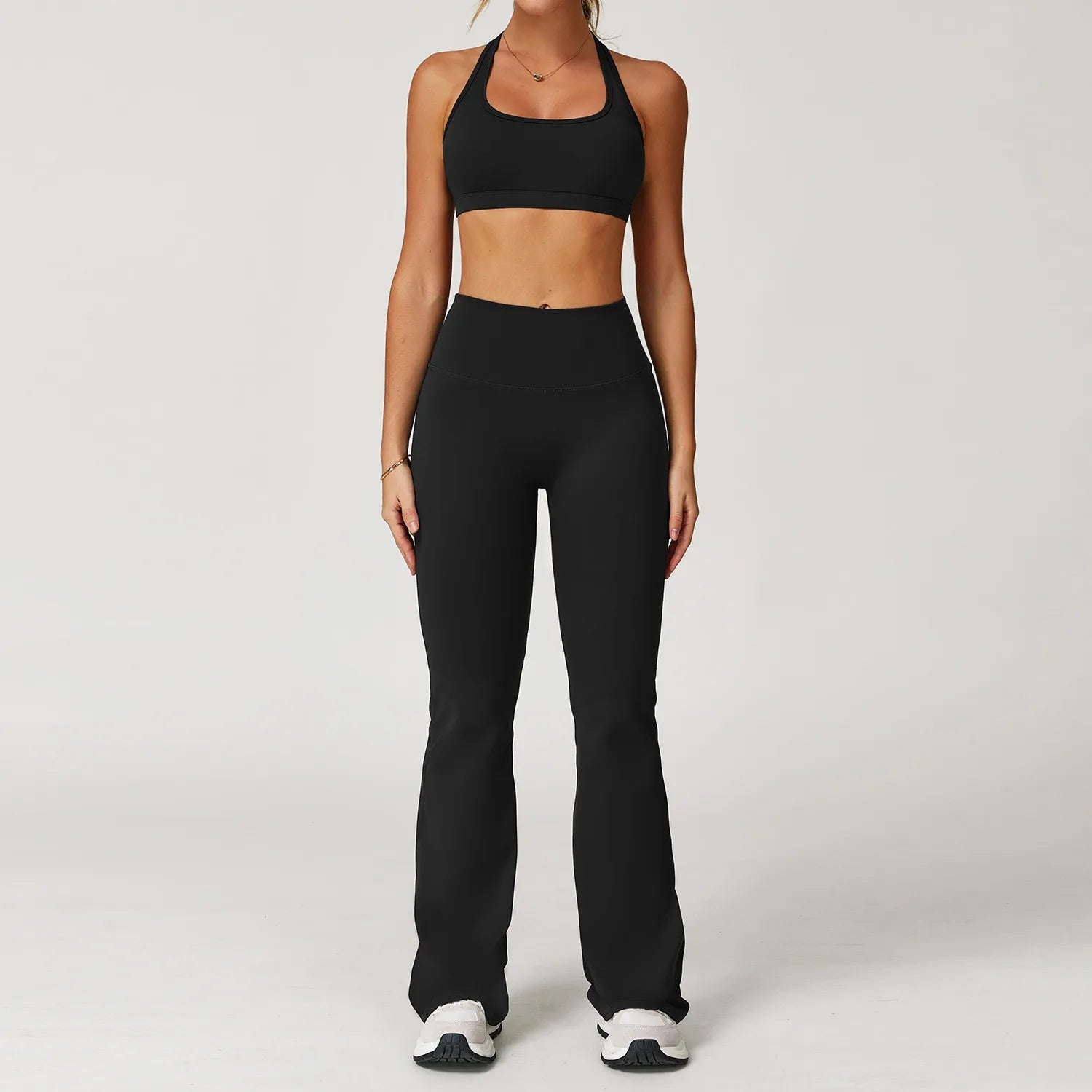 Xooie Fit women's workout set flared pants in black with matching sports bra and white sneakers