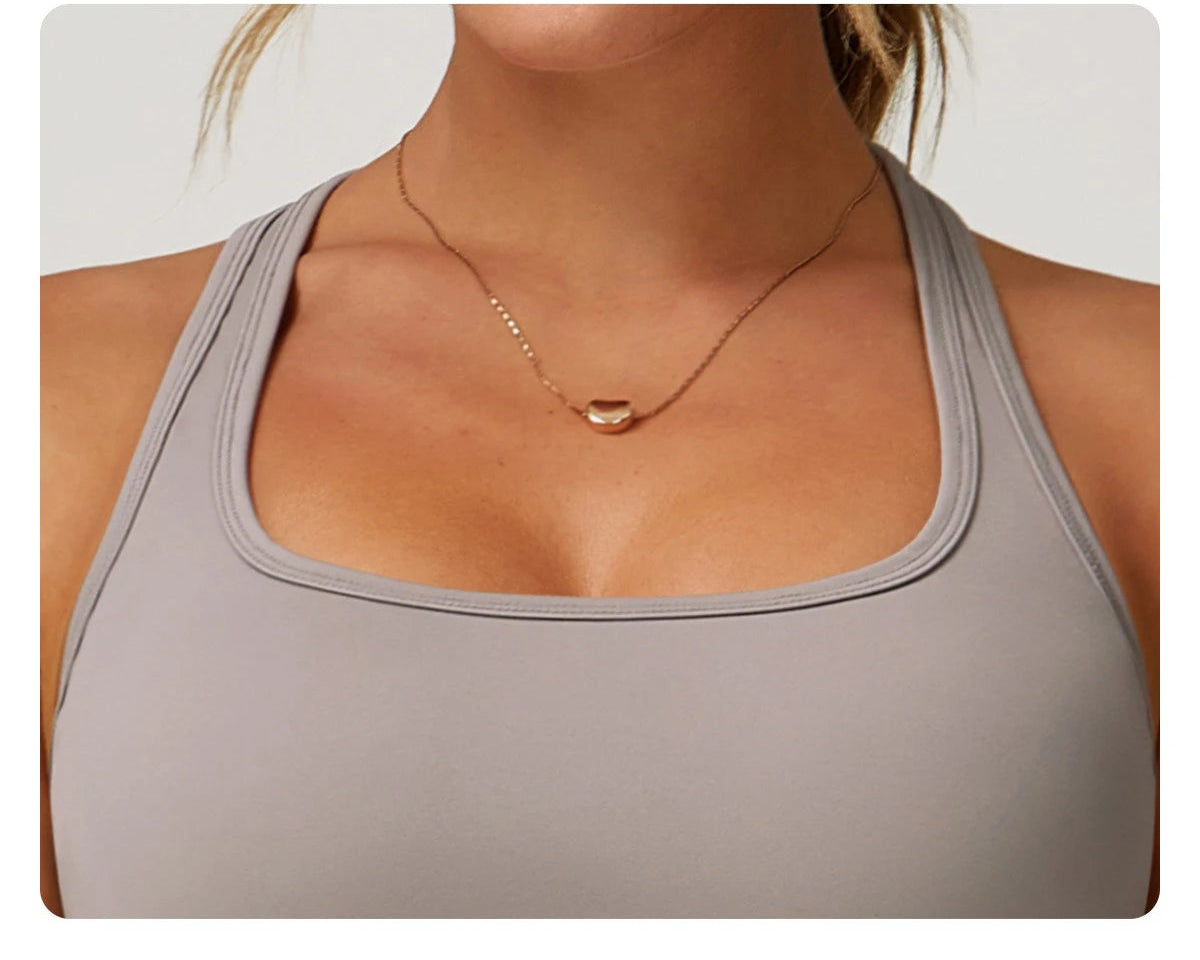 Close-up of a woman wearing a gray women's workout set flared pants top from Xooie Fit
