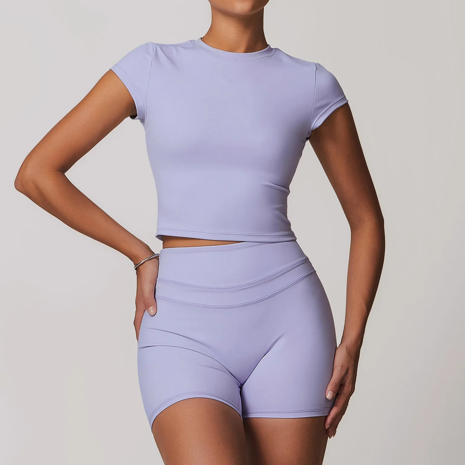 Xooie Fit womens workout set featuring a lilac short sleeve crop top and matching high-waisted shorts