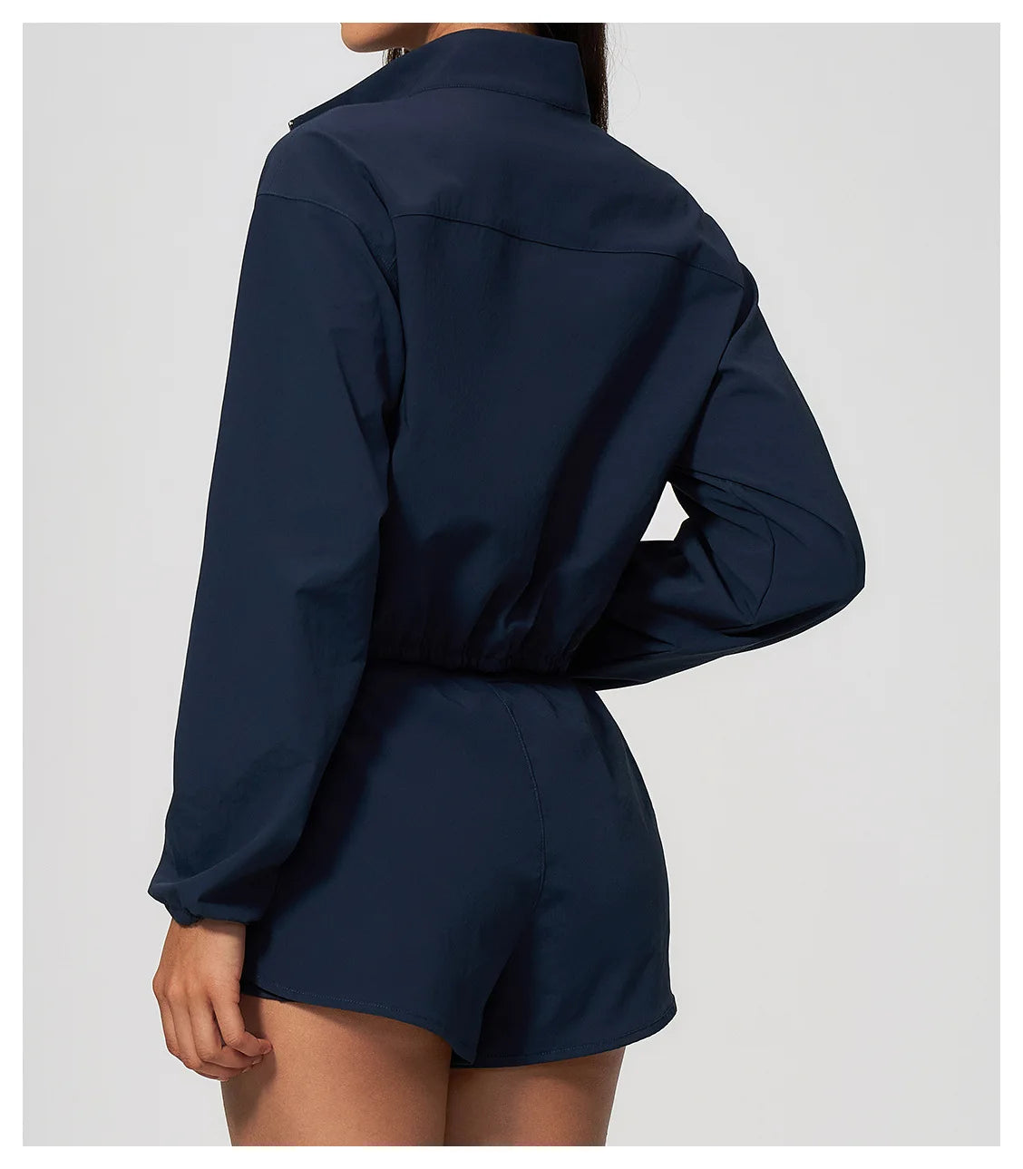 Navy zip-up sports jacket with long sleeves and elastic hem, back view