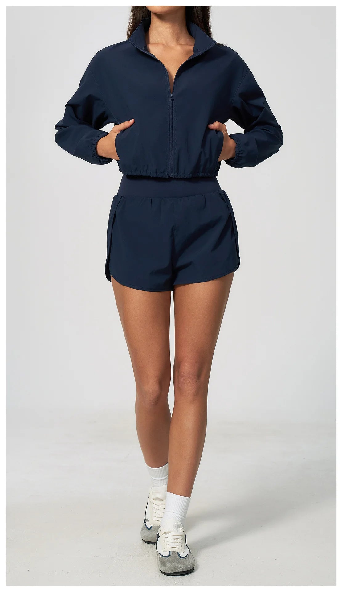 Navy zip-up cropped jacket with elastic waist and matching shorts, front view