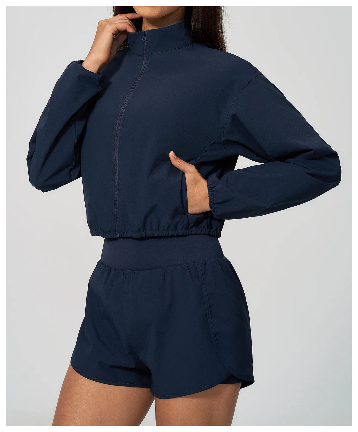 Navy zip-front cropped sports jacket with elastic waistband and long sleeves