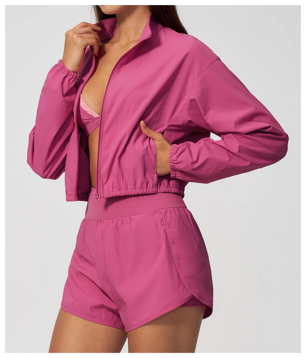 Pink zip-up athletic jacket with elastic cuffs and matching high-waist shorts