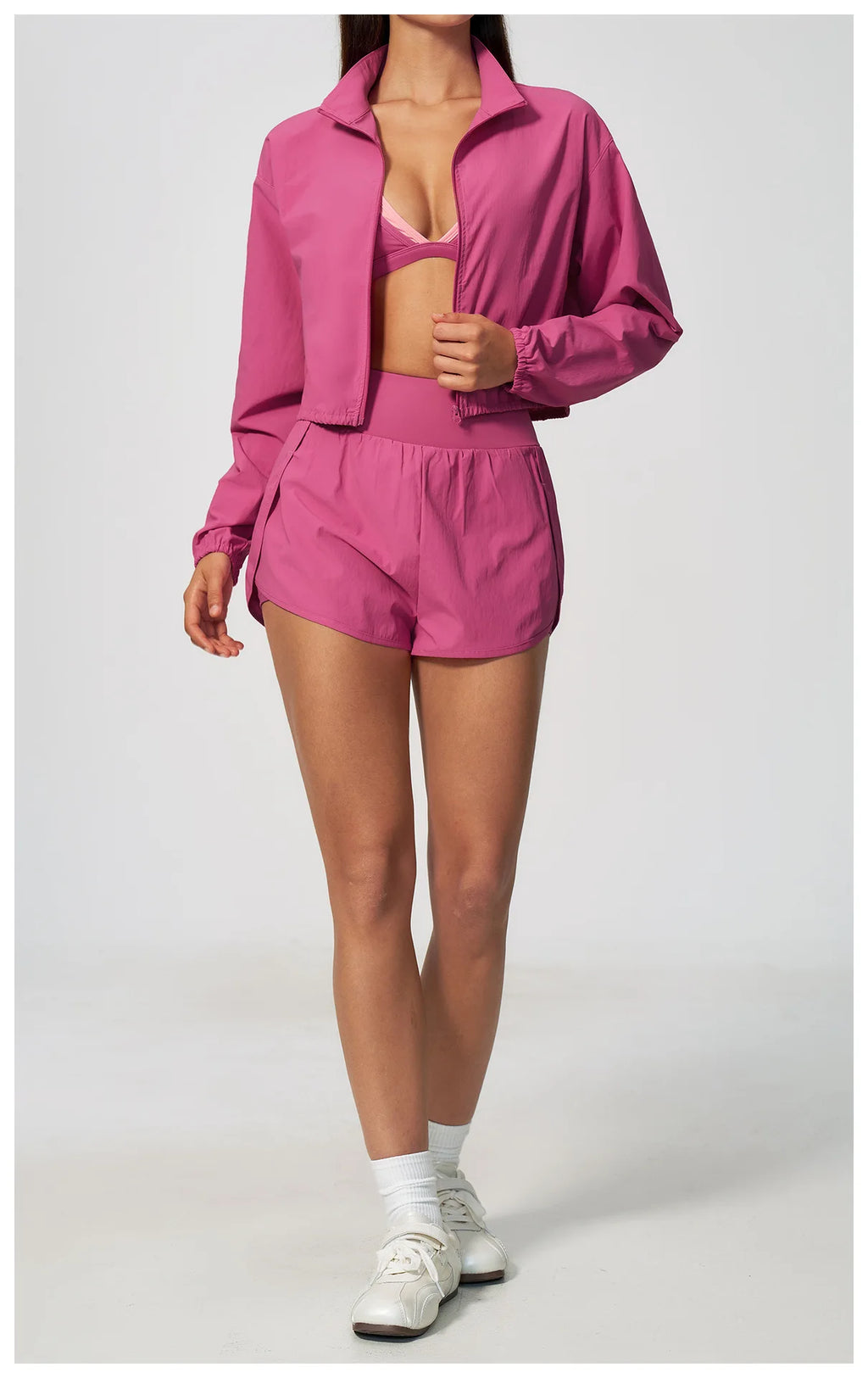 Pink zip-up cropped jacket with long sleeves and matching high-waist shorts