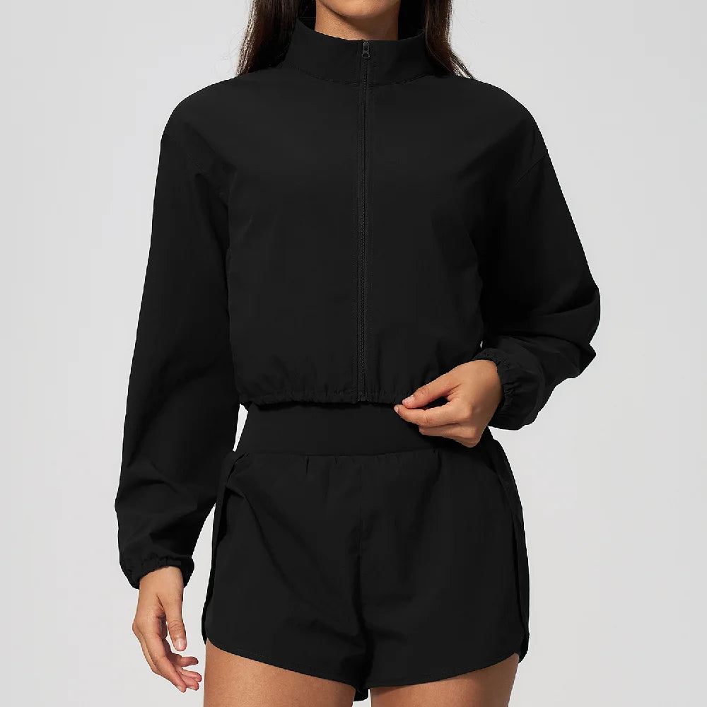 Black zip-up windbreaker jacket with high neck and matching elastic waist shorts set