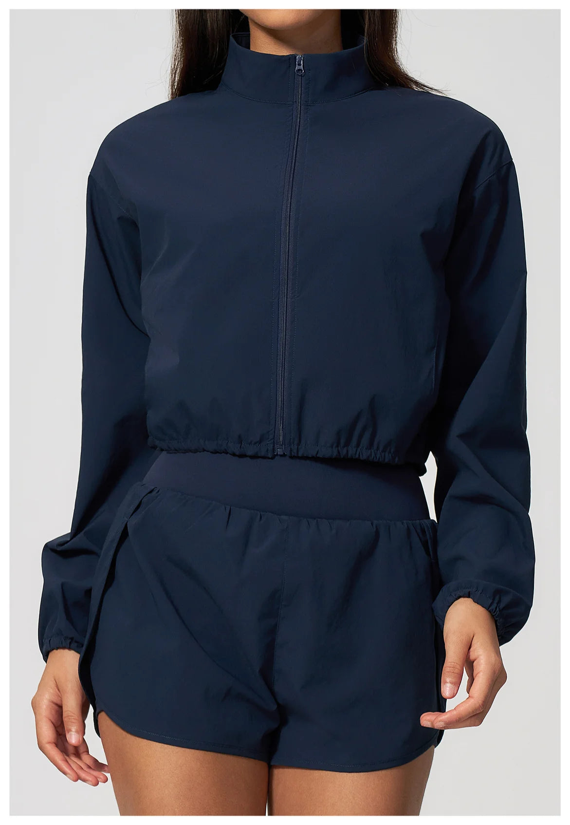 Navy zip-up cropped athletic jacket with elastic waist and matching high-waist shorts