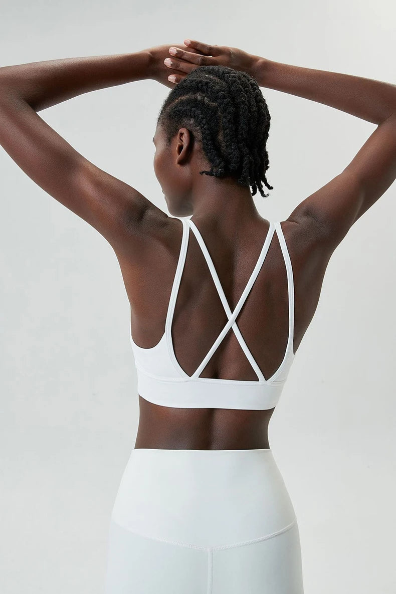 Back view of a Xooie Fit x-strap sports bra in white, featuring crisscross straps for added support