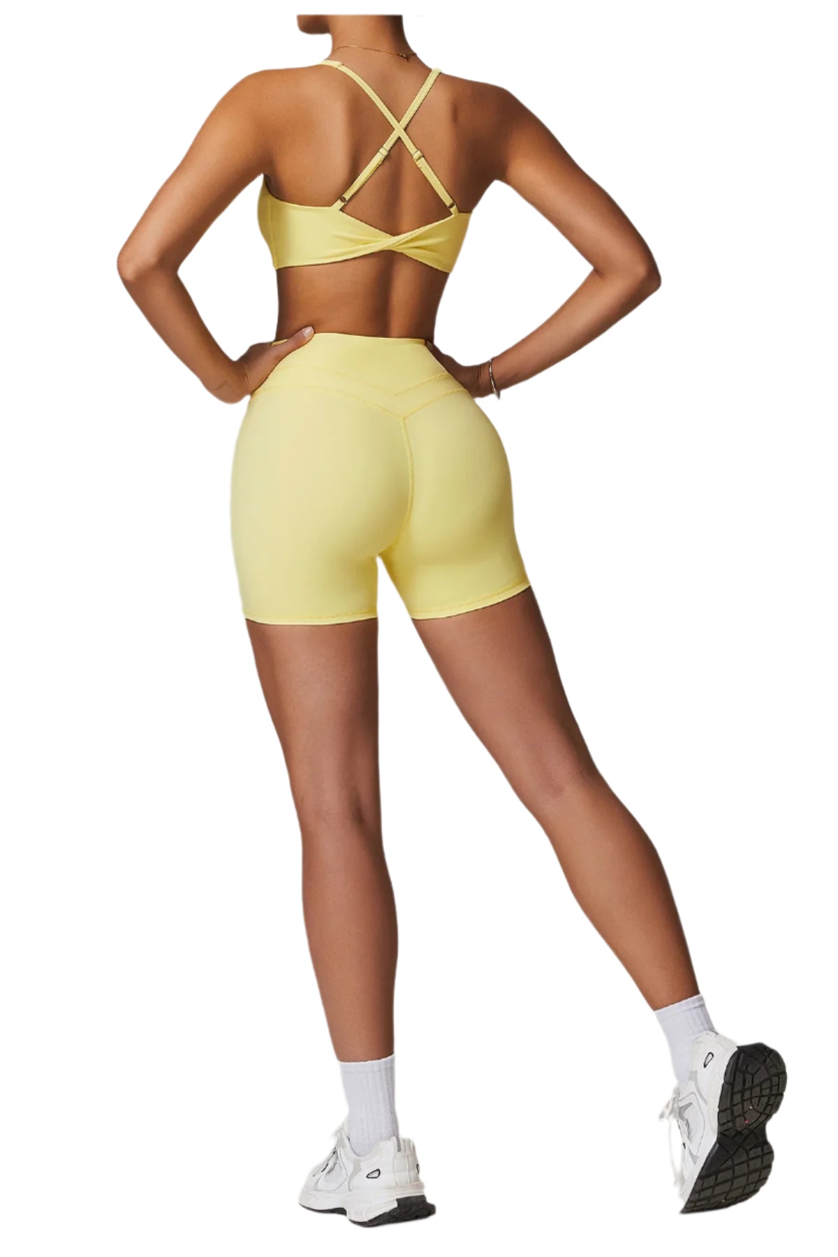Back view of women's fitness two-piece set in yellow featuring a stylish sports bra and shorts