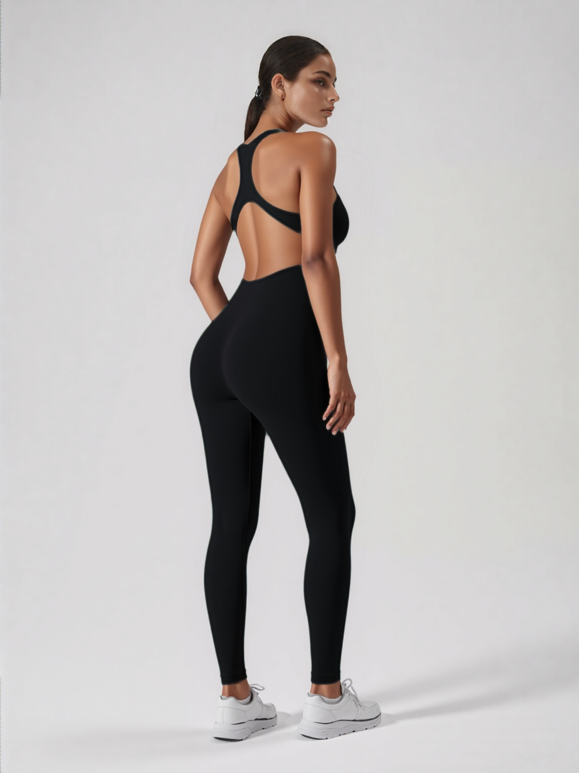 Xooie Fit black backless workout jumpsuit on model with racerback open back and full length fitted leggings