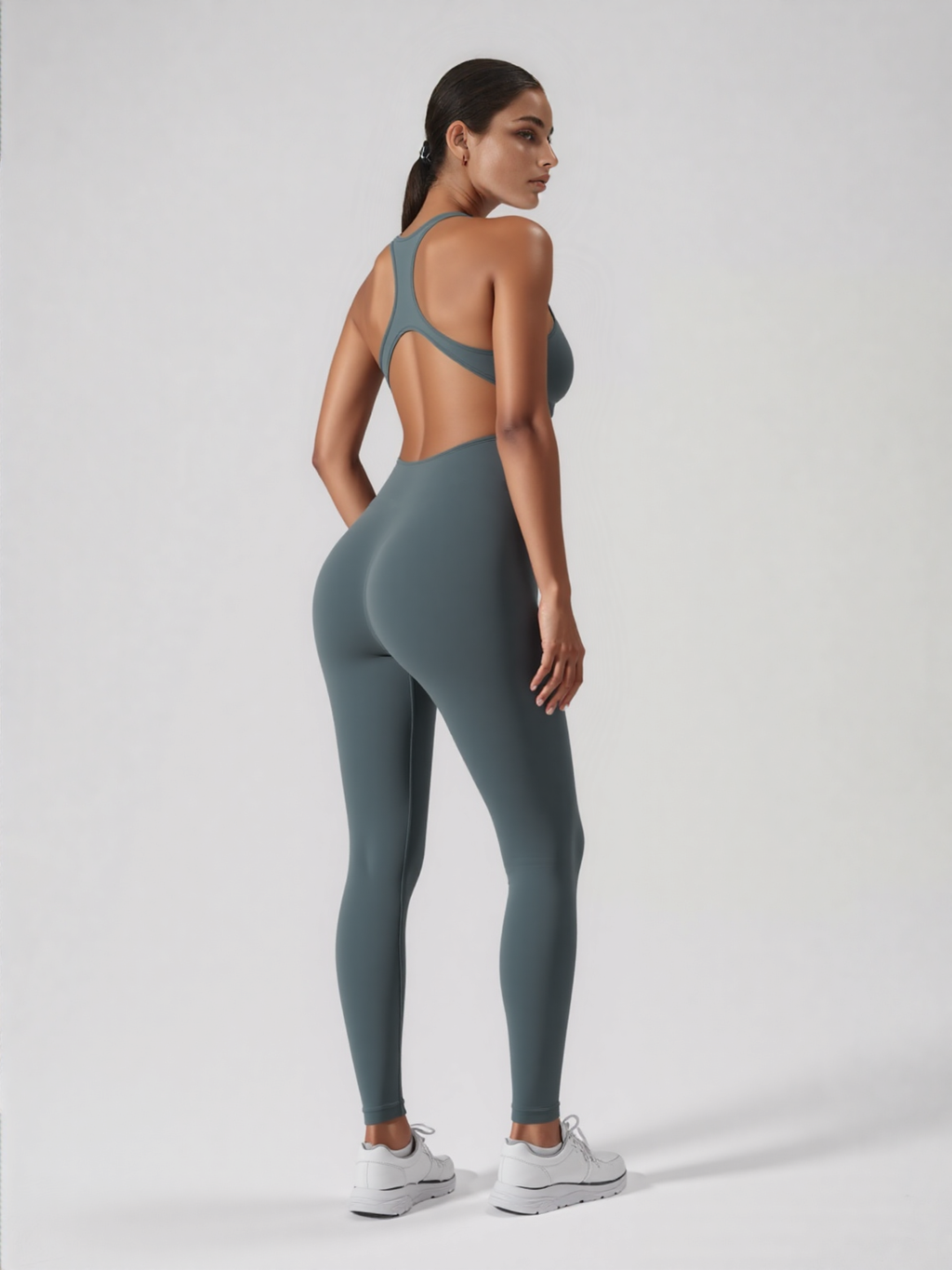 Xooie Fit backless workout jumpsuit in slate green modeled from back showing open racerback fit and leggings